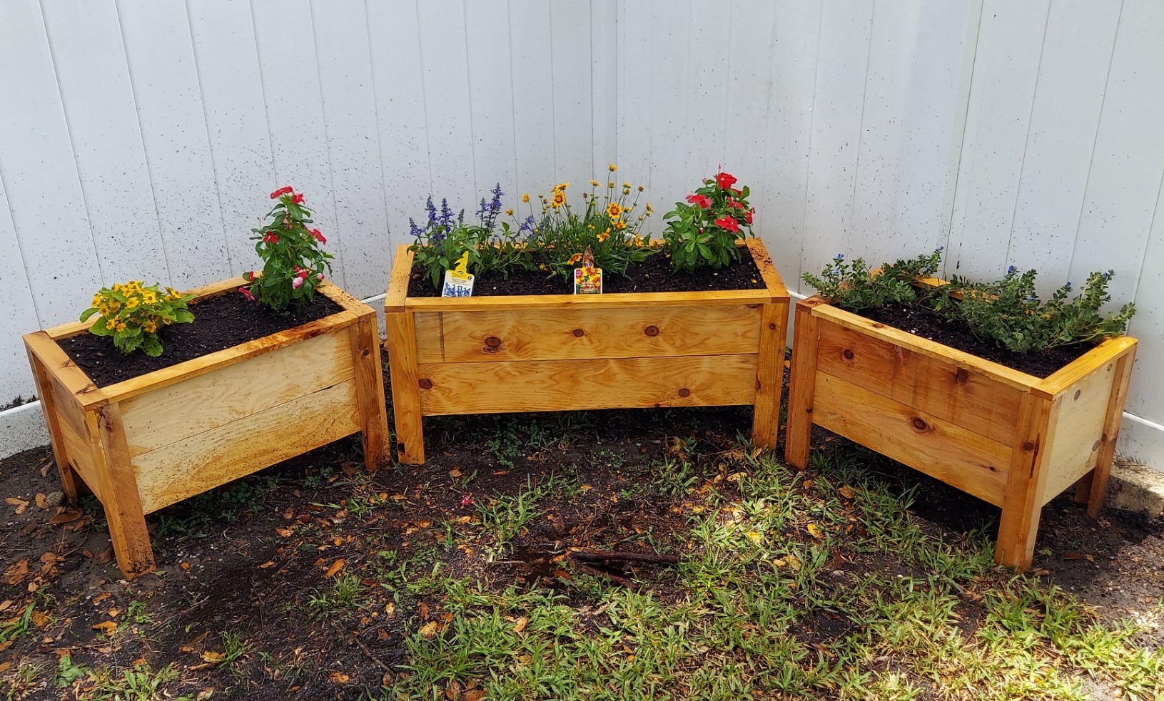 Medium Large Medium Client After Medium, Large, and Medium Cedar Planter Boxes with raised legs and newly potted colorful flowers